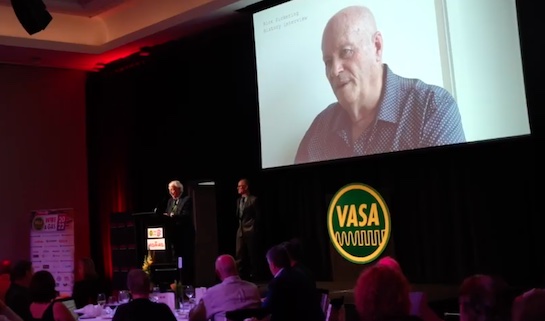 Ken Newton (left) at the Wire & Gas 2022 VASA Pioneer Award ceremony playing a video interview he did with Rick Pickering